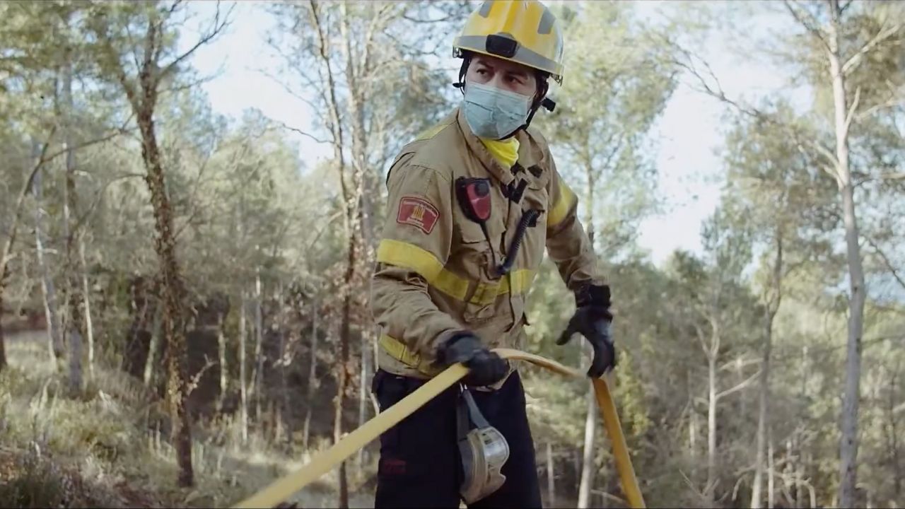 A firefigther fighting a forest fire.