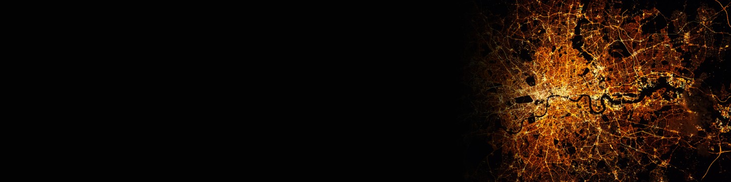 이미지는 밤에 도시의 상세한 항공 뷰를 보여주는데, 불이 켜진 거리와 도로가 복잡한 네트워크를 형성하고 있습니다.