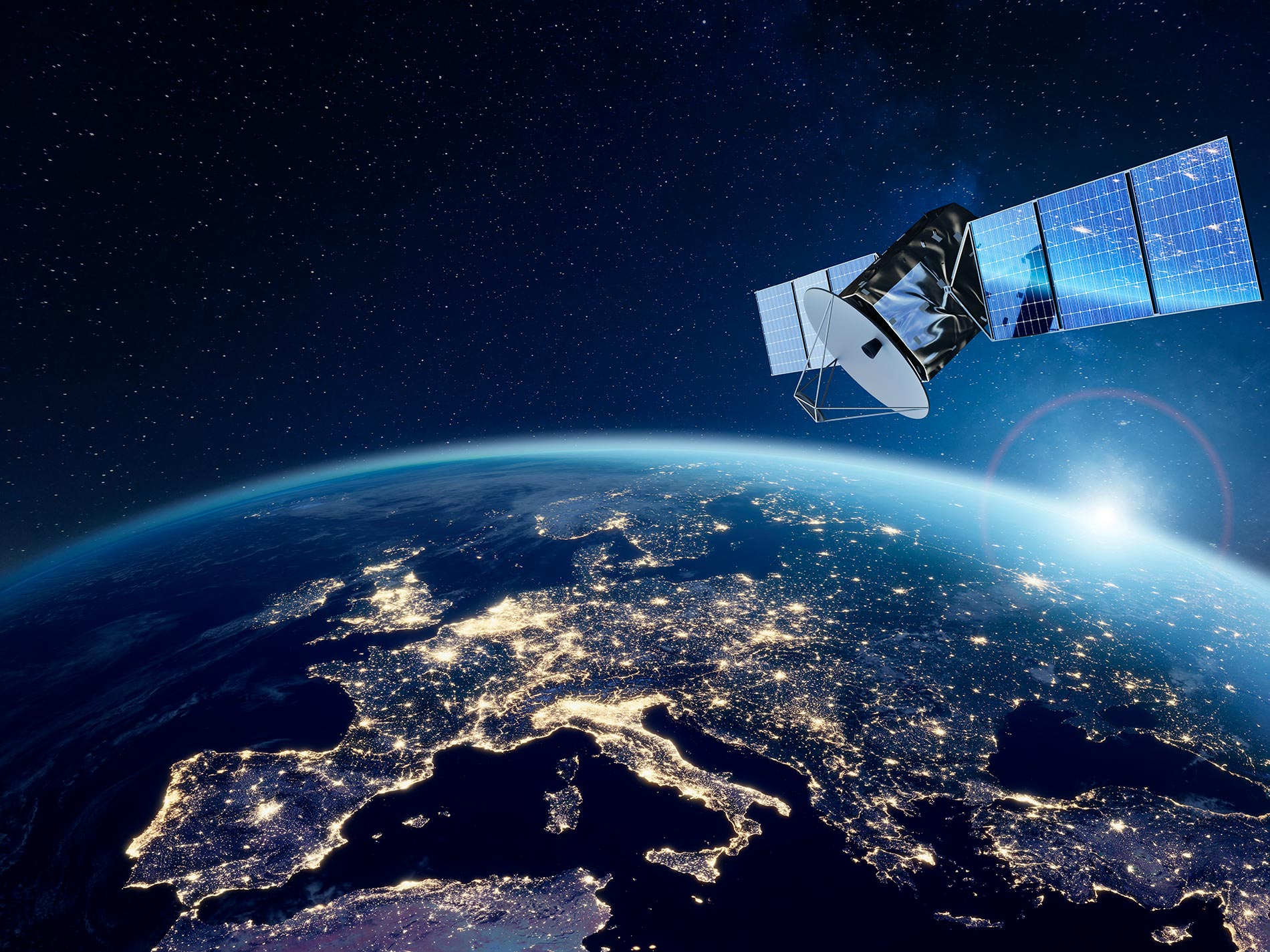 Un satélite de comunicaciones orbita sobre la Tierra, con una vista clara de Europa iluminada por la noche.