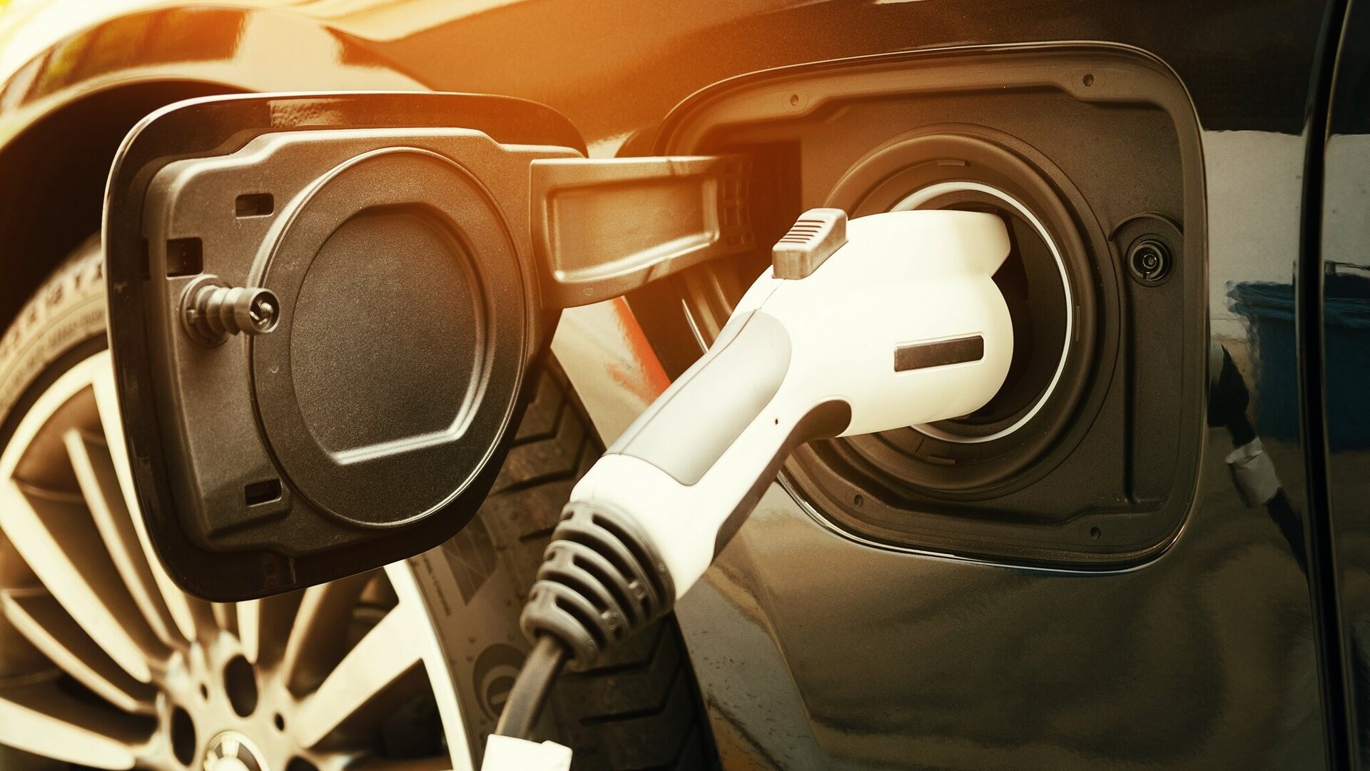 Close-up view of an electric vehicle being charged through its side charge port