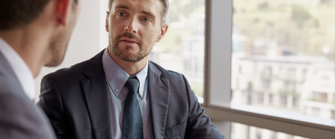 Two Men In A Meeting Next To Window